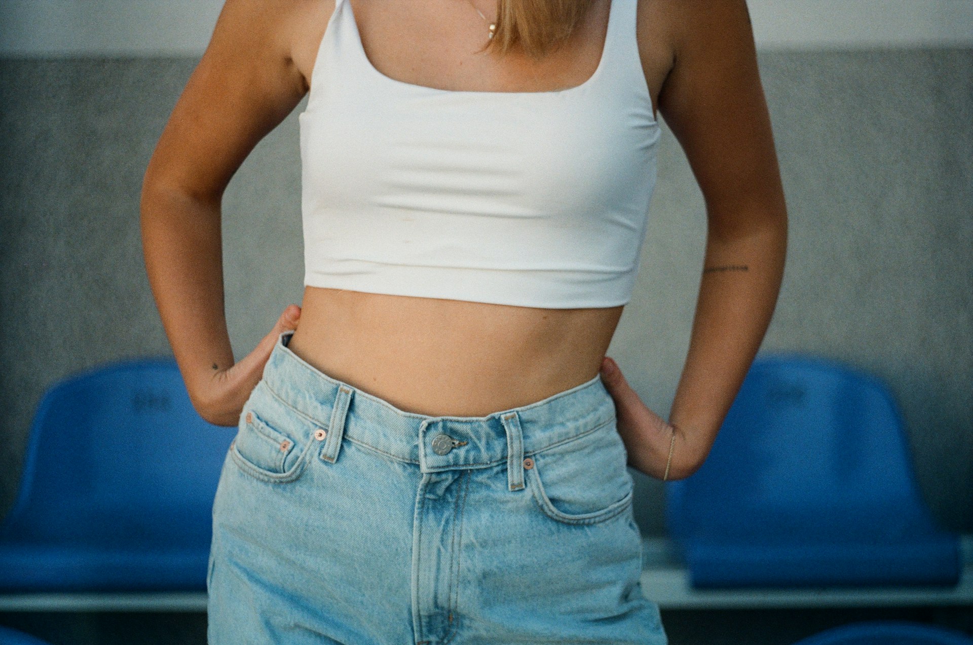 Amincissement woman in white tank top and blue denim jeans